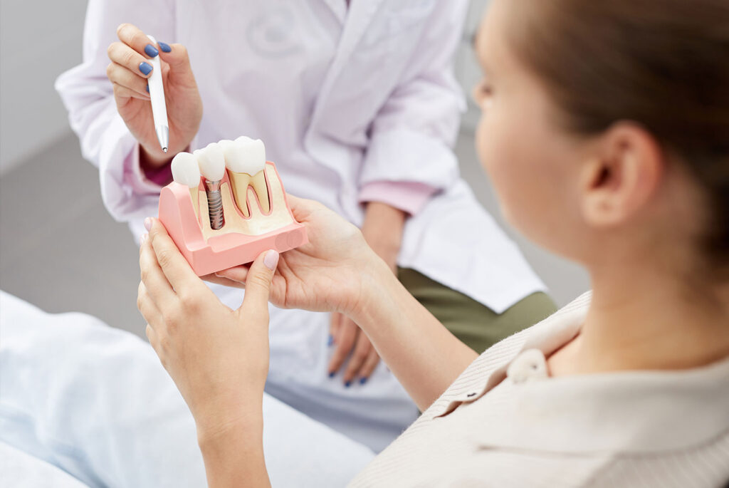 patient looking closely at dental implant model?