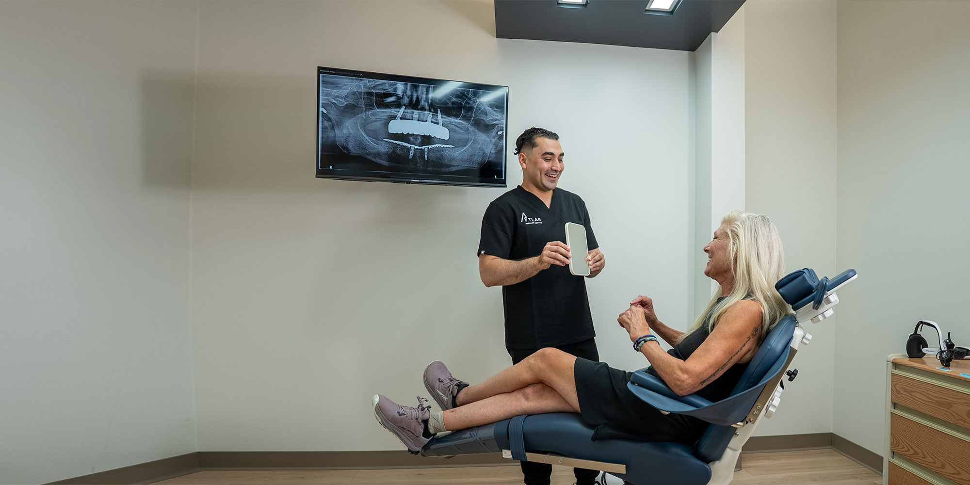 doctor holding up mirror for patient to see after treatment results