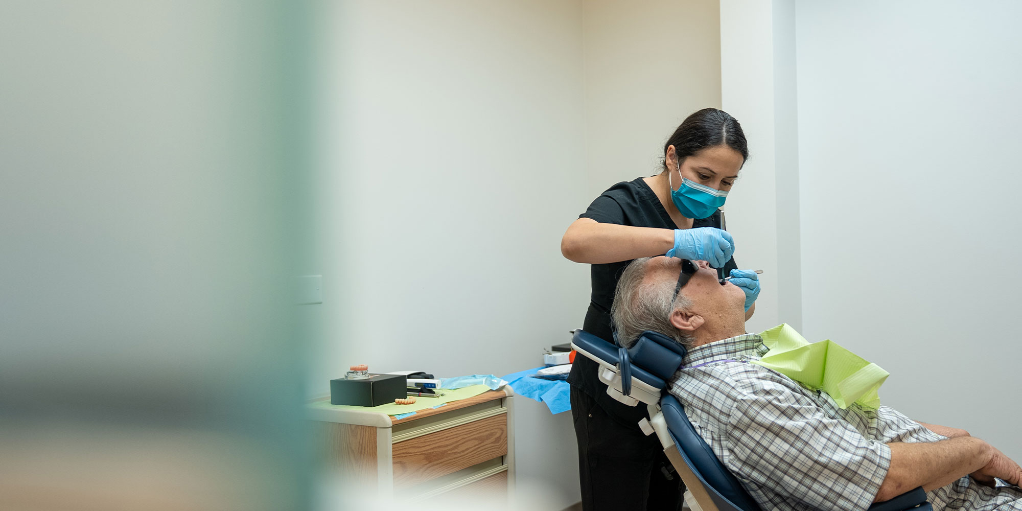 staff member doing a dental examination on a dental implant patient